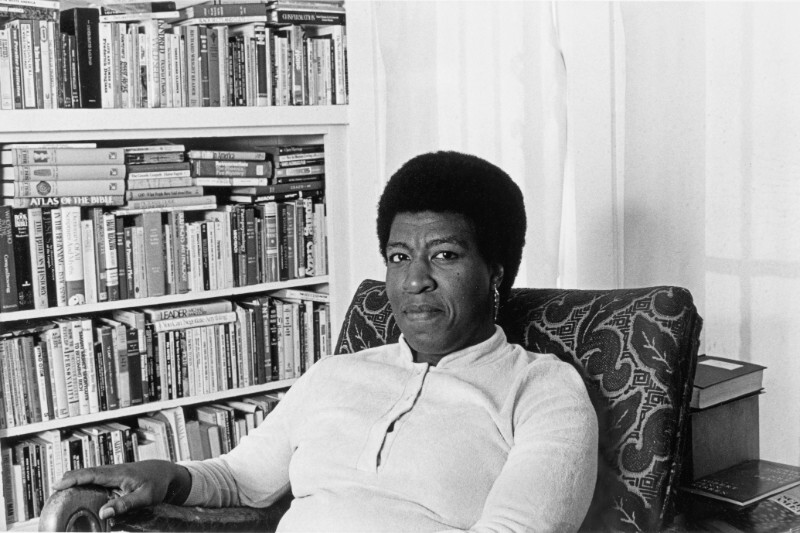 Patti Perret, photograph of Octavia E. Butler seated by her bookcase, 1986. The Huntington Library, Art Collections, and Botanical Gardens. © Patti Perret