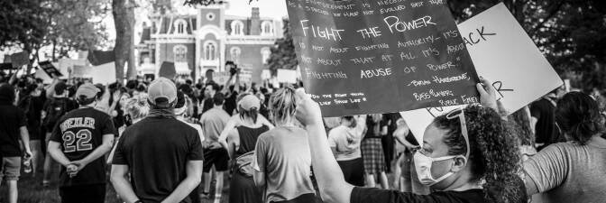 Woman holds a poster describing the need to fight the abuse of power in a demonstration to protest the killing of George Floyd in Des Moines, Iowa. | Phil Roeder/Flickr/Creative Commons License