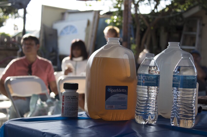 Brown water displayed on a table in Compton, CA from Sativa Water District