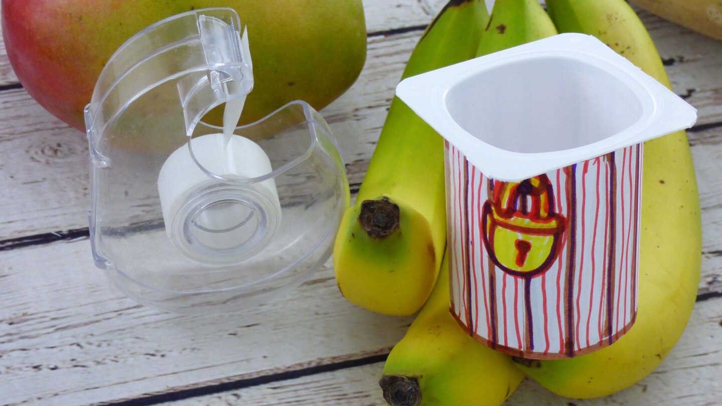 Tape the strips of paper around the yogurt cups.