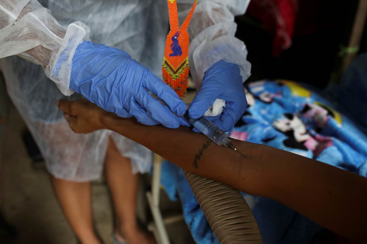 Vanderlecia Ortega dos Santos, 32, a nurse from the Witoto tribe, an indigenous ethnic group, who has volunteered to provide the only frontline care protecting her indigenous community of 700 families from the COVID-19 outbreak, injects dipyrone i