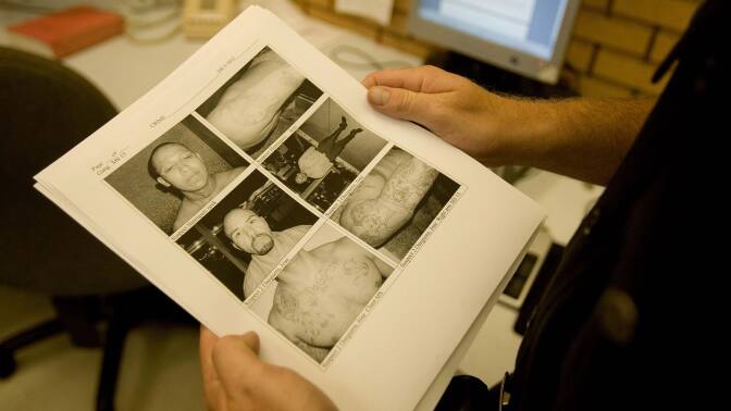 Members of LAPD Gang Unit look at photos of suspects | photo by Robert Nickerson/Getty Images