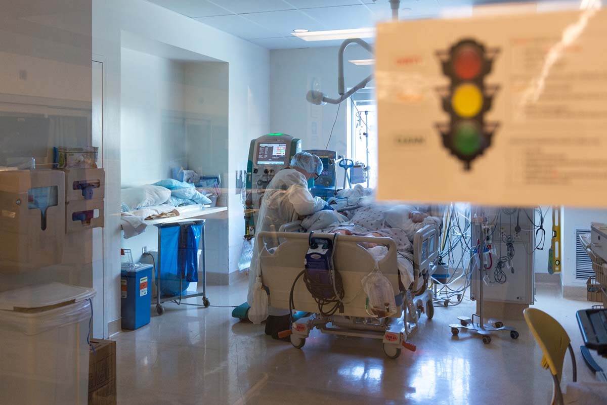 Nurse Yvonne Yaory checks on a coronavirus patient who is connected to a ventilator. | Heidi de Marco/California Healthline