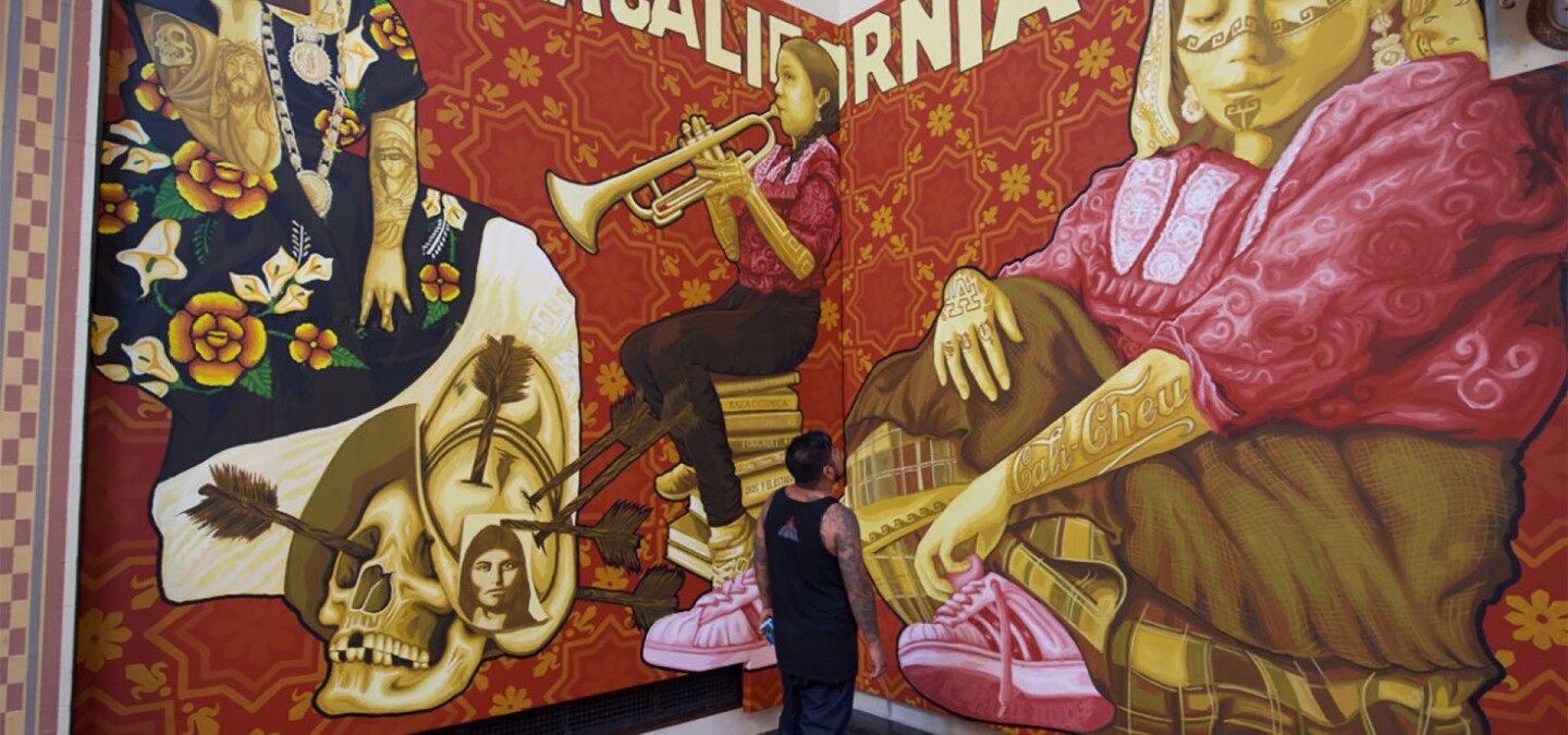 Dario Canul of artist collective Tlacolulokos stands in front of mural that depicts the two sides of Oaxaca | Gary Leonard