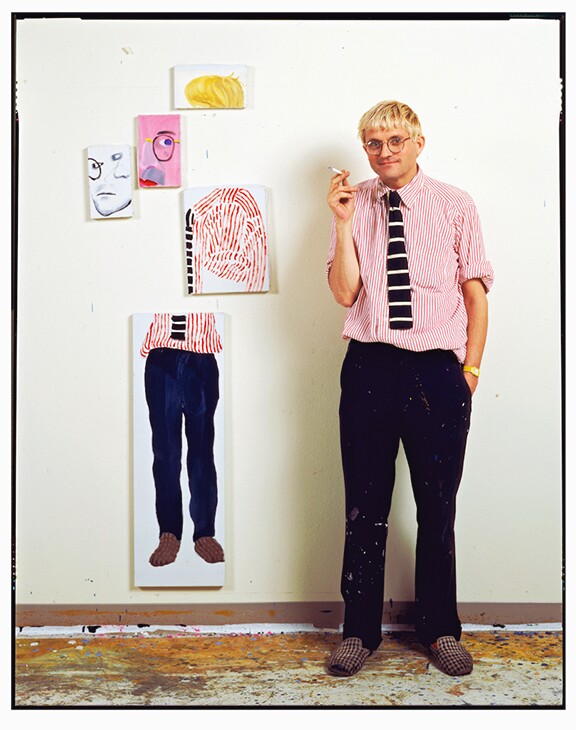 David Hockney, next to a similar cubist painting of himself in his Hollywood Hills studio, 1984. Titled "David Hockney - Hollywood Hills studio," 1984. | Photo: Jim McHugh.