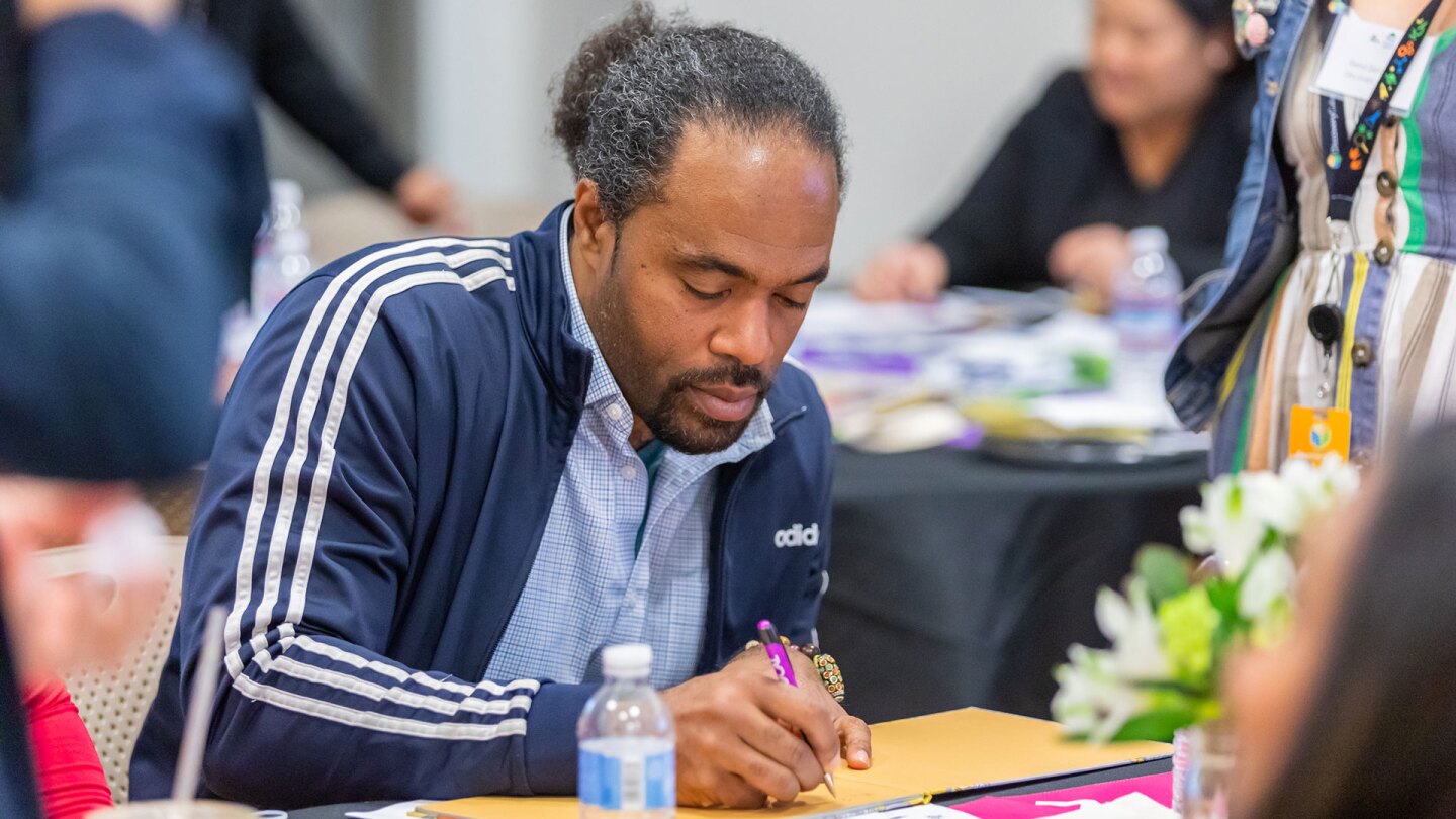 Omo Moses signs autographs at the PBS SoCal Family Math Convening. | Mae Koo