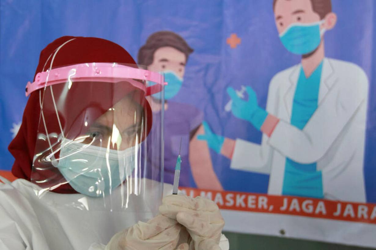 A health care worker prepares a dose of China's Sinovac Biotech vaccine for the coronavirus disease (COVID-19), during a mass vaccination for vendors at the Tanah Abang textile market in Jakarta, Indonesia, February 17, 2021.