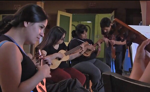 Community members practice playing and writing son harocho as part of the legalize street vending initiative.