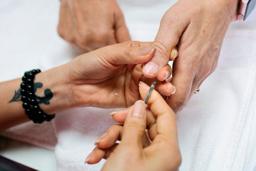 Salon worker working on a customer's manicure