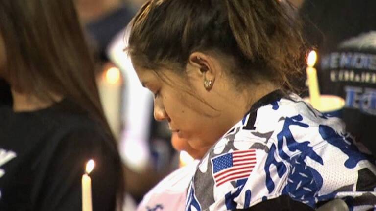 Woman bows head at vigil to honor Las Vegas massacre victims. | Democracy Now