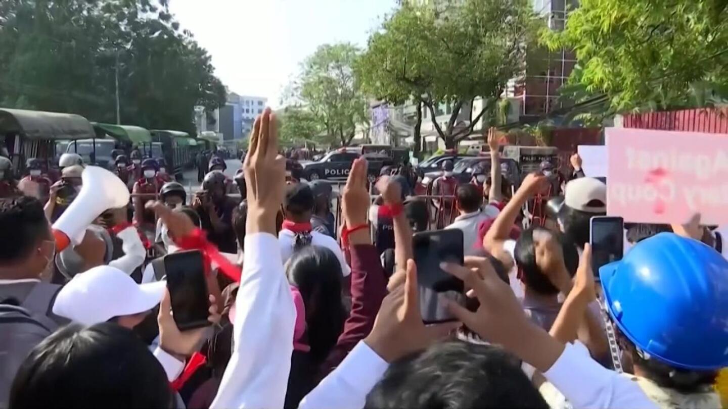 A group of protesters gather as they hold up their phones.