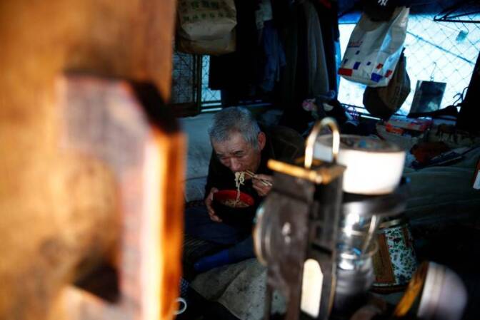 RCHIVE PHOTO: Homeless Makoto Shinbo eats his lunch at his makeshift house at Miyashita park in Tokyo, Japan, February 17, 2017. Picture taken on February 17, 2017. | REUTERS/Kim Kyung-Hoon