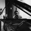 The Sound of Gordon Parks - Closing, a photo of a pianist sitting at the piano with headphones on 