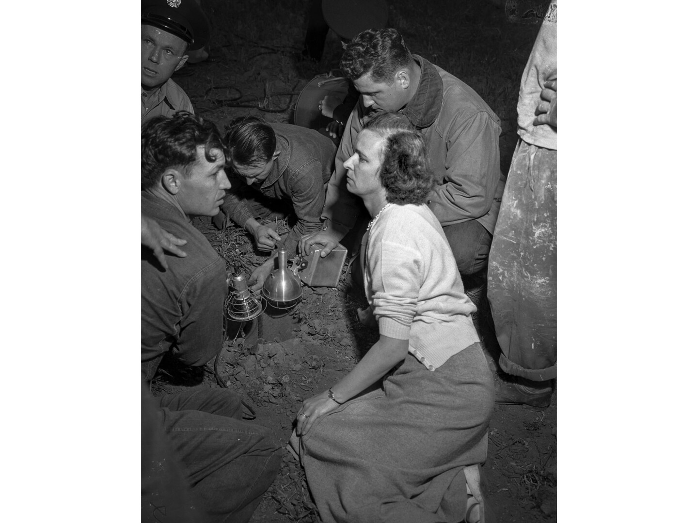 Jeanette Lyon, the aunt of Kathy Fiscus, sits by the well as police and firefighters examining the well her niece fell down.