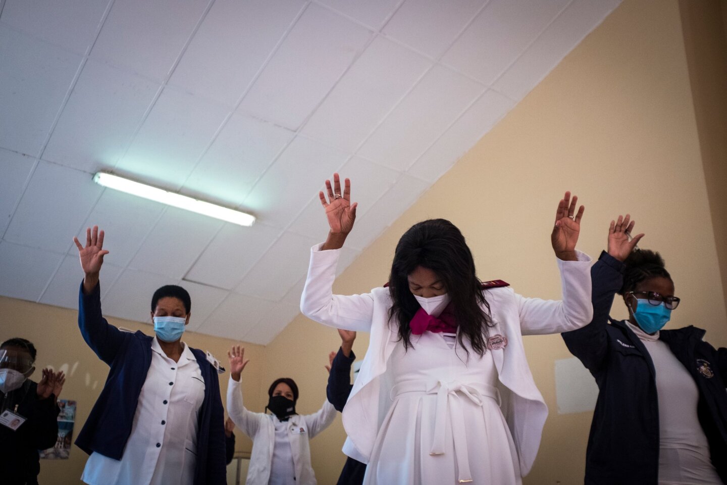 Nurses raise their hands in prayer during an event in honor of the World Health organisation's (WHO) "Year of the Nurse" | Thomson Reuters Foundation/Gulshan Khan