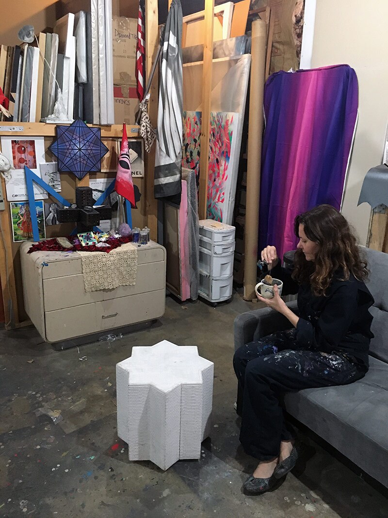 Mary Anna Pomonis drinks tea in front of her studio altar, 2020. | Courtesy of the artist. Photo: Justin Stadel.