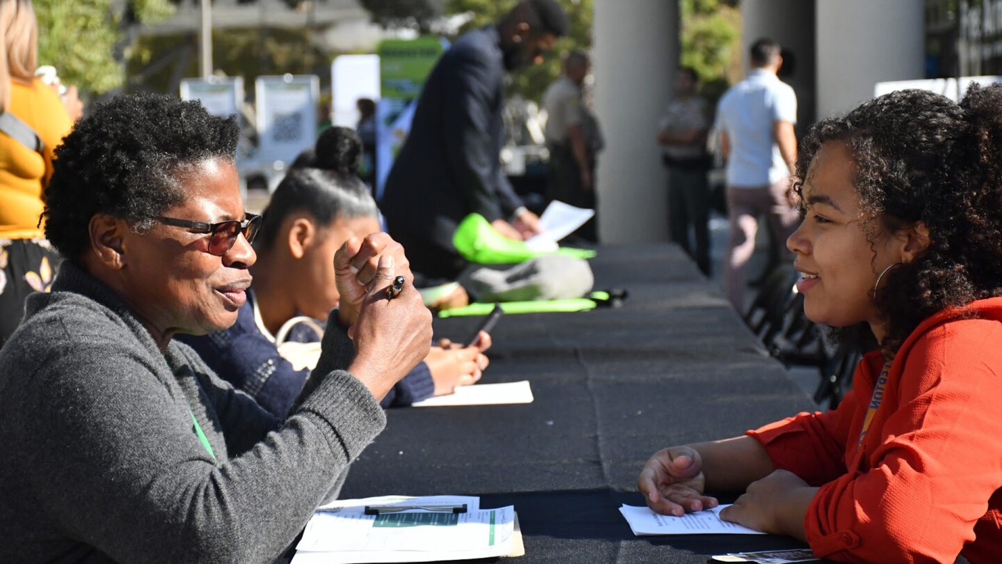 A young woman speaks to a career coach at a job fair. | Courtesy of LeadersUp