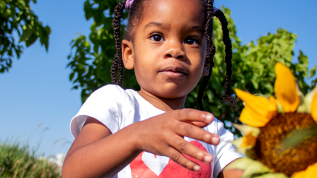 Close up of a young child with a sunflower.