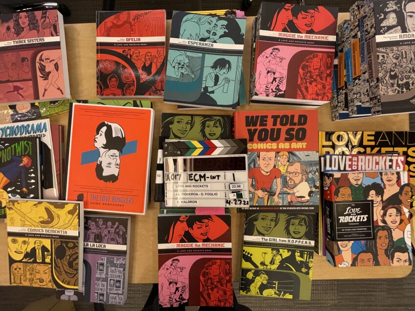 A collection of "Love and Rockets" comic books in boxes.