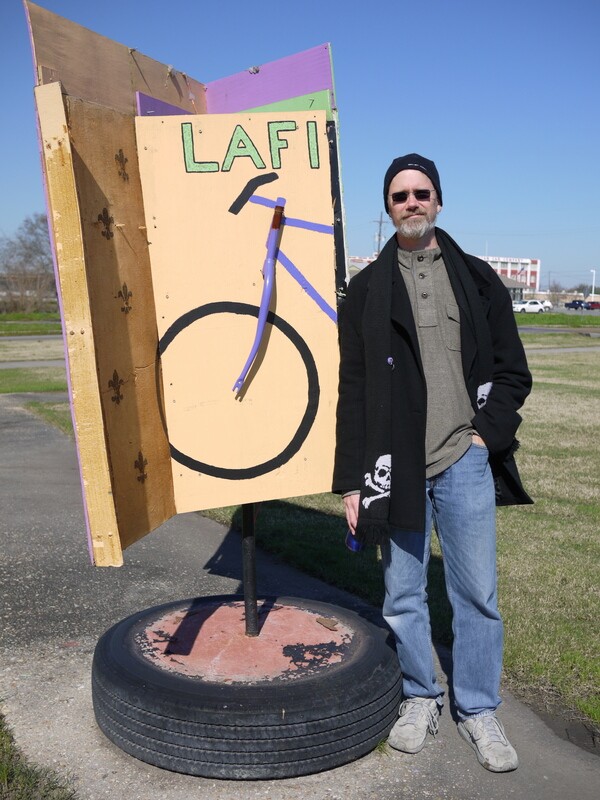Bart Everson standing by a green room installation designed to be a tri-panel wind activated structure | Photo by George Villanueva