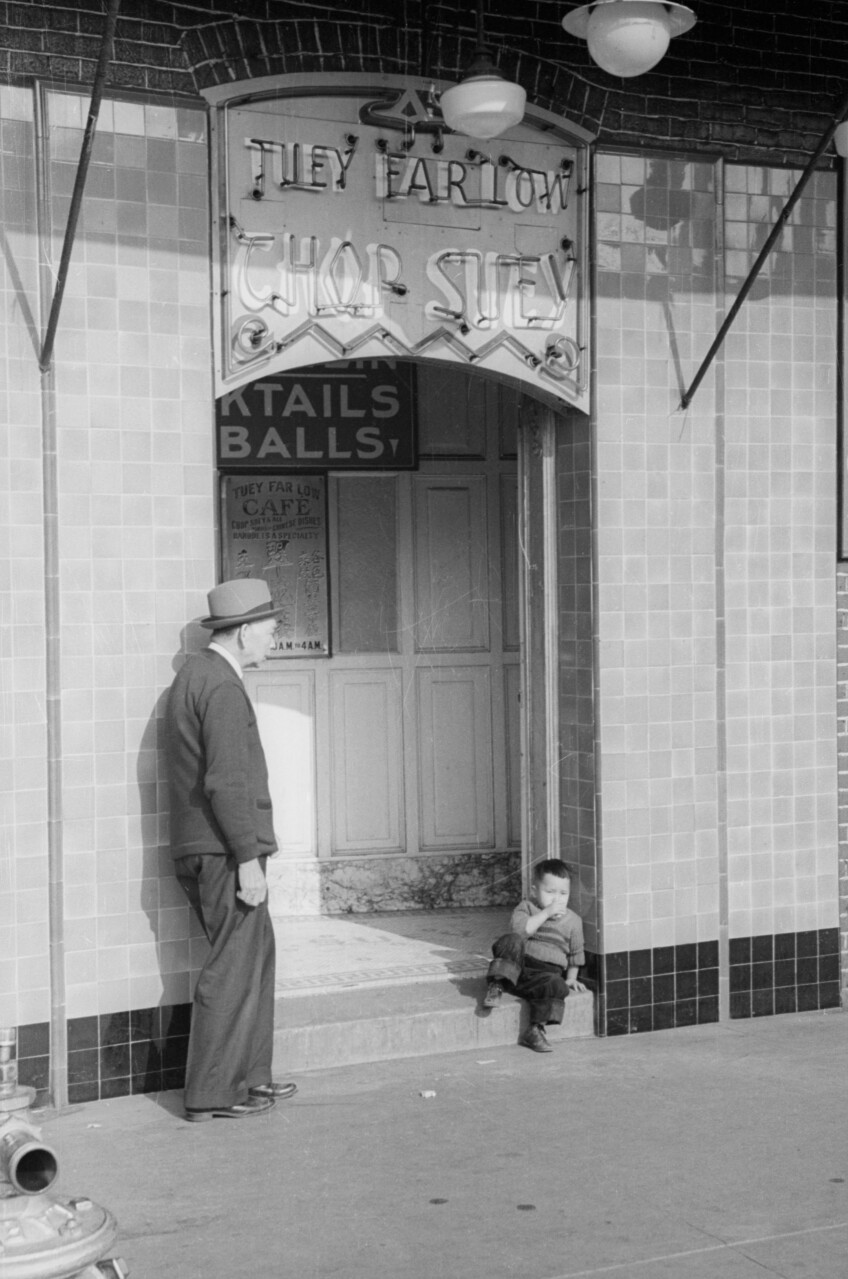 An older man and a little boy stand together outside The Farlow Chop Suey in Old Chinatown.