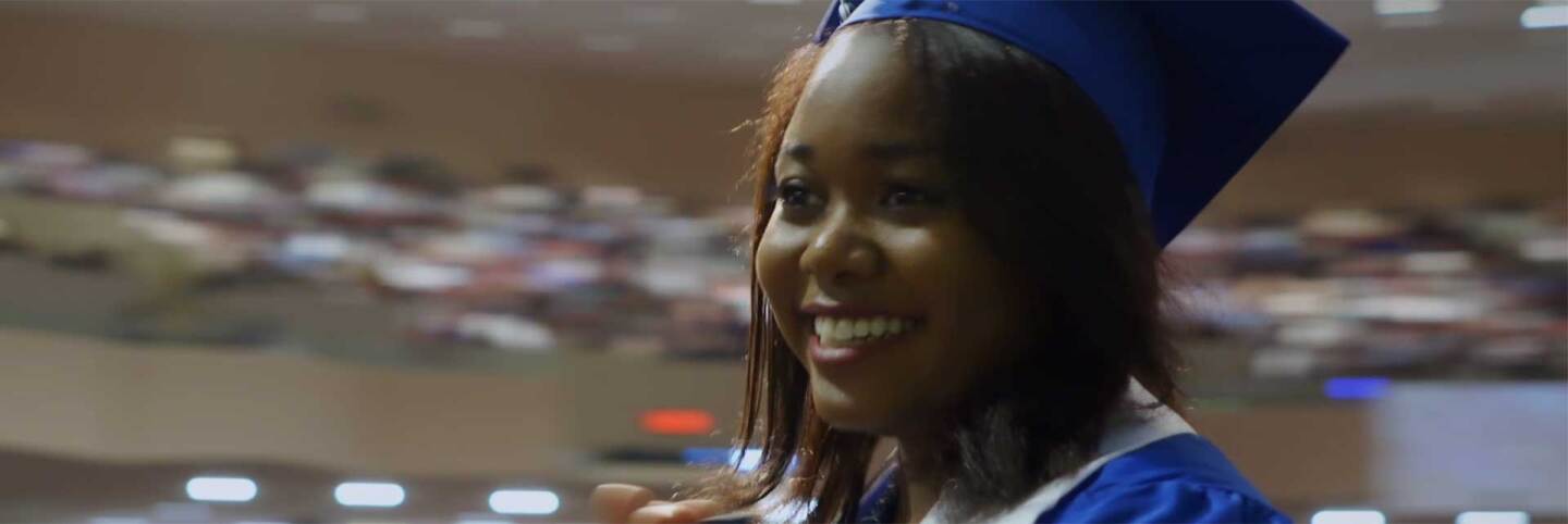 op image is a still of Kierra Byrd, fellow in the Young Women's Advisory Council, receiving her college diploma. Still from the "Global Mosaic" episode "Young Women Rising."