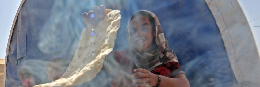 A displaced Iraqi girl bakes bread at the Hammam al-Alil camp for internally displaced people south of Mosul on May 26, 2017. | Karim Sahib/AFP/Getty Images