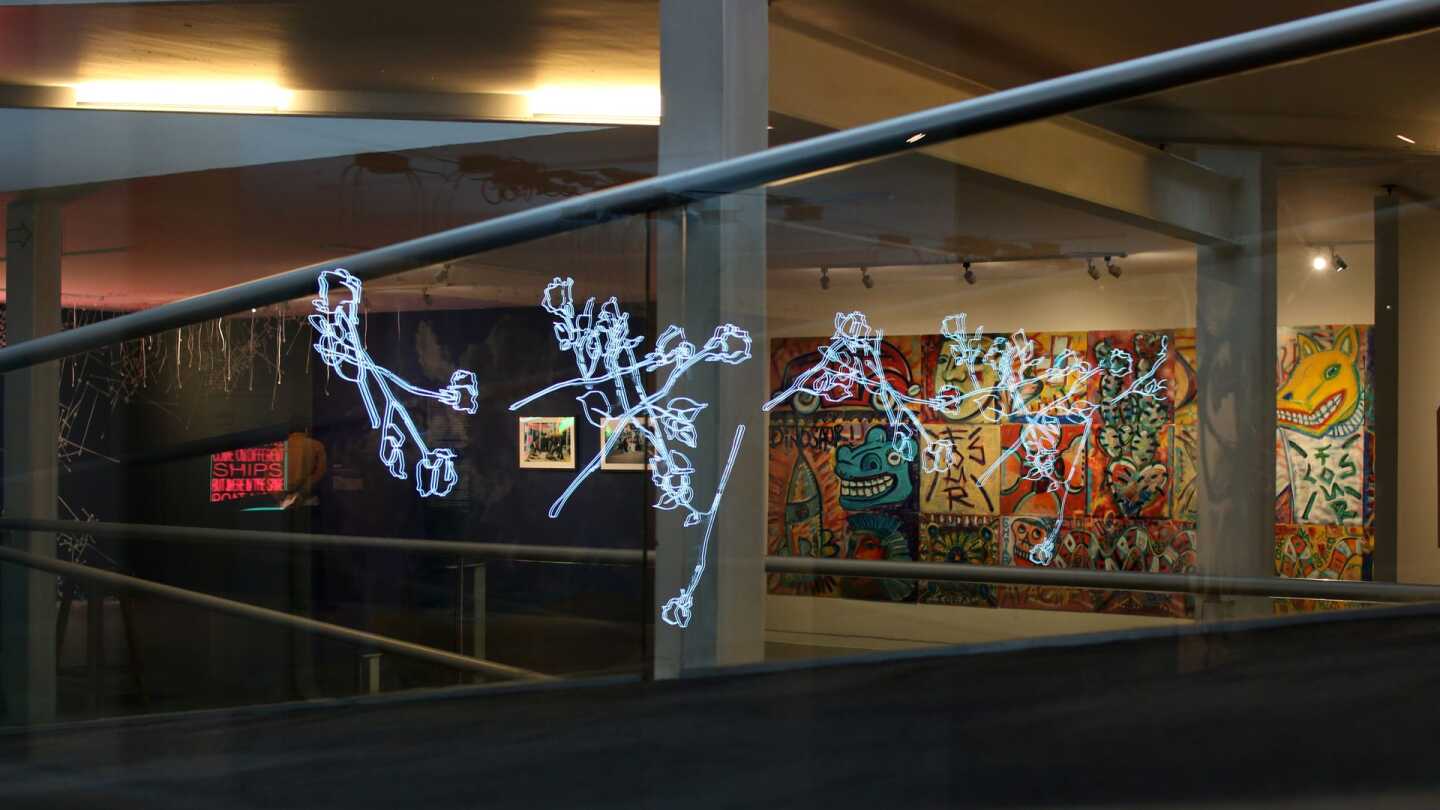"Bridges in a Time of Walls" exhibition wide shot. "Strewn" by Leticia Maldonando in the foreground with "Los Four 20th Anniversary Collective Mural" in the background. | Samanta Helou Hernandez