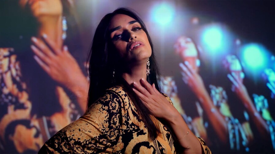 Still from Liraz's "Nozi Nozi": A woman stands with video feedback of her own image behind her.