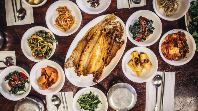 An overhead shot of banchan, Korean side dishes, laid out on a table.