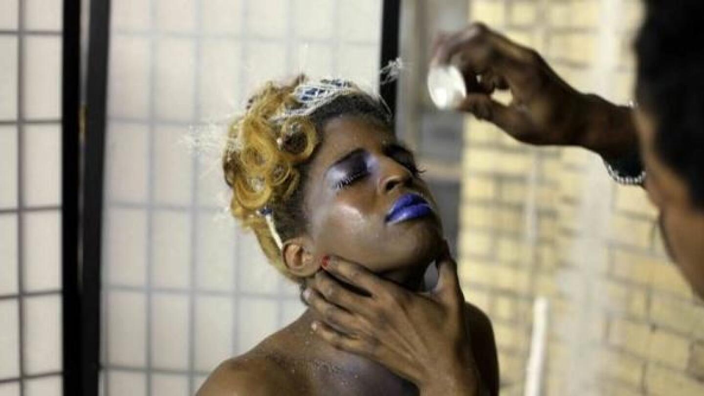 A person gets their makeup done by someone else.