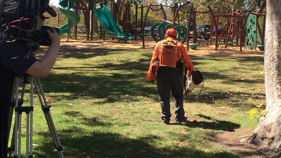 A man operates a leafblower in the park