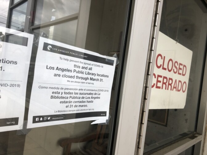 Signs outside the Los Feliz Branch Library explain that the library is closed to prevent the spread of COVID-19. | Matt Tinoco/LAist