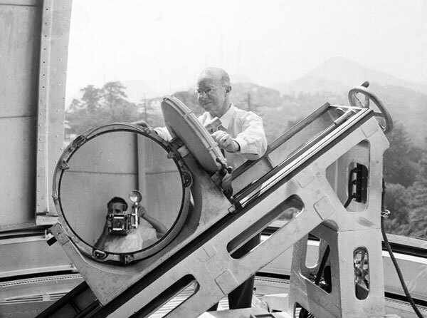 Mount Wilson telescope operator Joseph Hickox polishes a mirror while an Examiner photographer takes a self-portrait. 1955 photo courtesy of the Los Angeles Examiner Collection, USC Libraries.