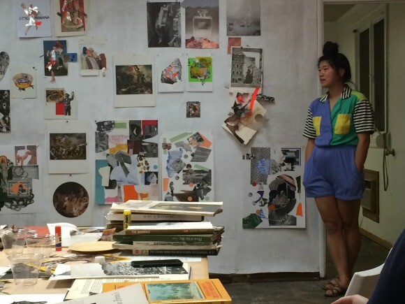 Soyoung Shin, a participant in the Collage Night workshop at the Women's Center For Creative Work, stands by the collages during the end of the night critique. | Photo: Robby Herbst.