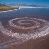 A view of Robert Smithson's land art called "Spiral Jetty" made primarily of black basalt rocks and salt crystals.