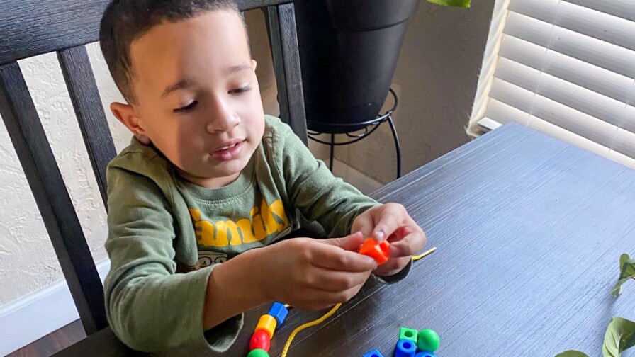 A child makes a bead bracelet