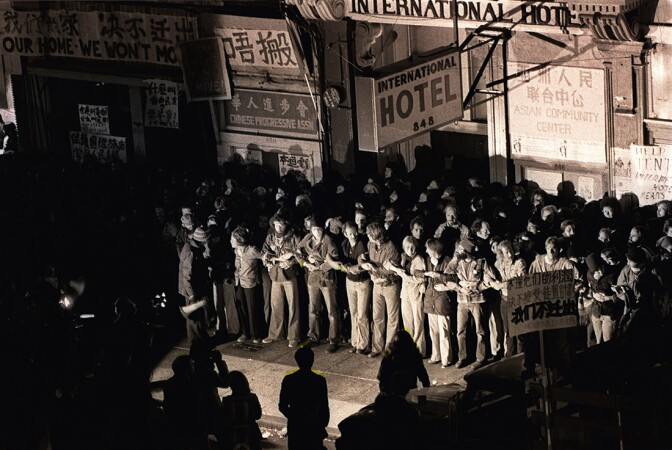Hundreds of protesters linking arms in front of the International Hotel in San Francisco