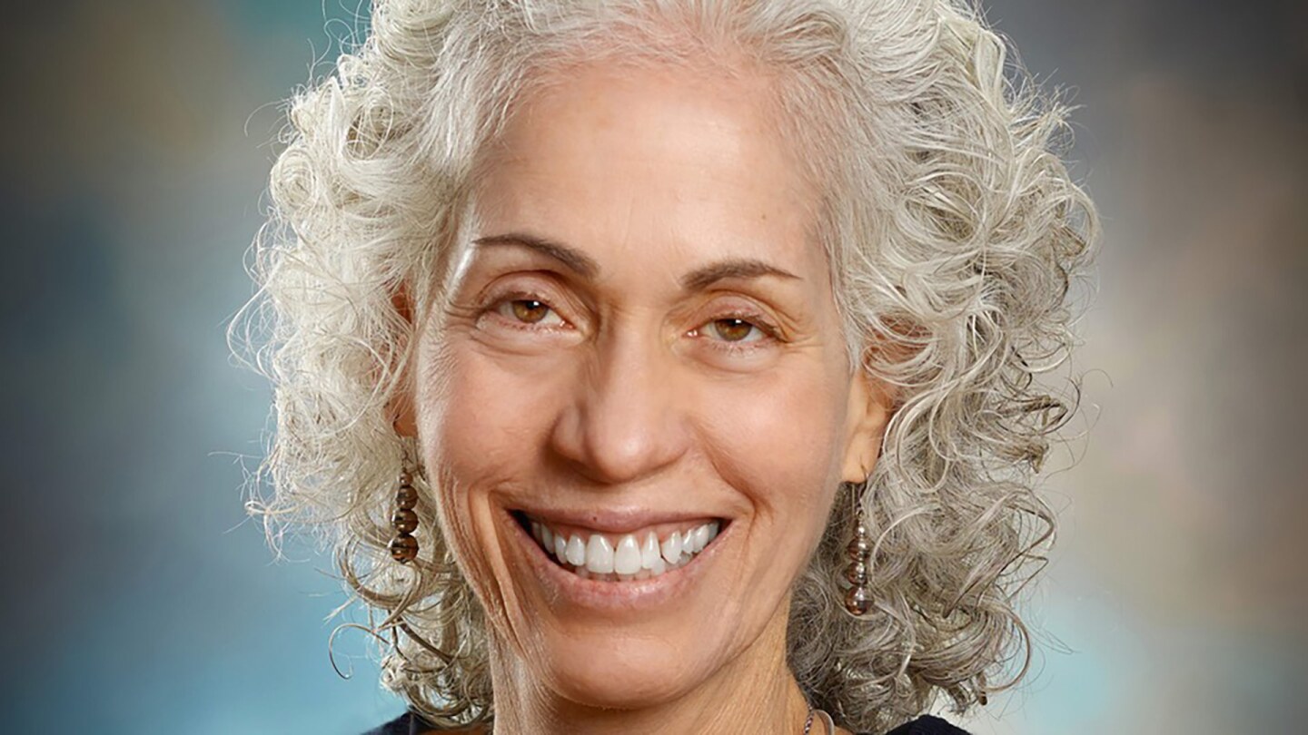 Barbara Ferrer smiles wearing a black top and her signature white curly hair.
