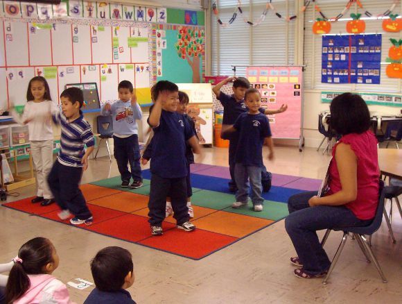 Kindergarten Teacher Michelle Pampo encouraging children to act out what characters are doing in the story she is reading.