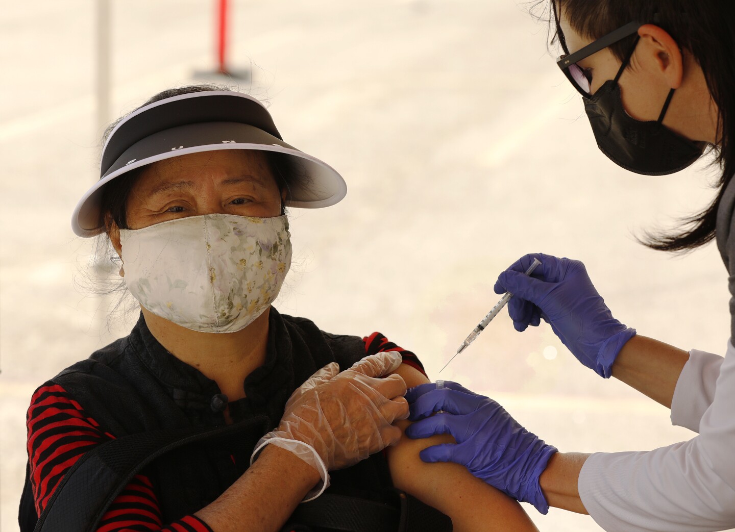 Hui Hua Kwan, 71, receives the Pfizer COVID-19 vaccine from registered nurse Cristy Michel in Chinatown on Wednesday, Feb. 24, 2021 in Los Angeles, California.