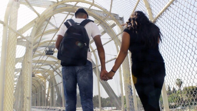 Roots|Raices: Young Couple Holding Hands on Bridge