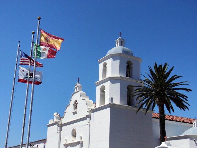 The white church and flags at Mission San Luis Rey