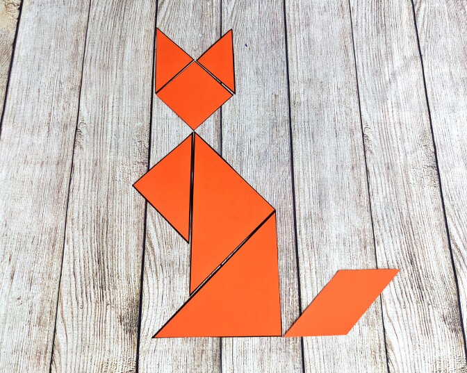A tangram is arranged in the shape of a cat.
