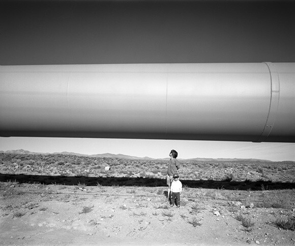 Walker and Ellen under LA Aqueduct, Owens Valley, CA, 1992. | Photo: Robert Dawson