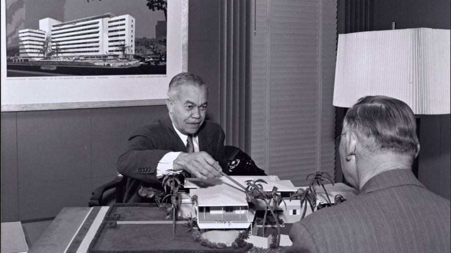 Paul R. Williams on the other side of the desk showing plans | J. Paul Getty Trust. Getty Research Institute, Los Angeles