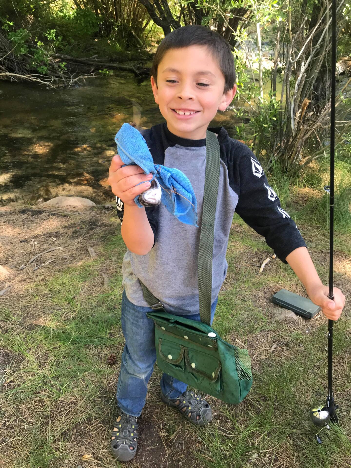 A young boy holds a fishing rod.