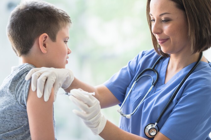 Young Boy Receiving an Immunization Needle stock photo