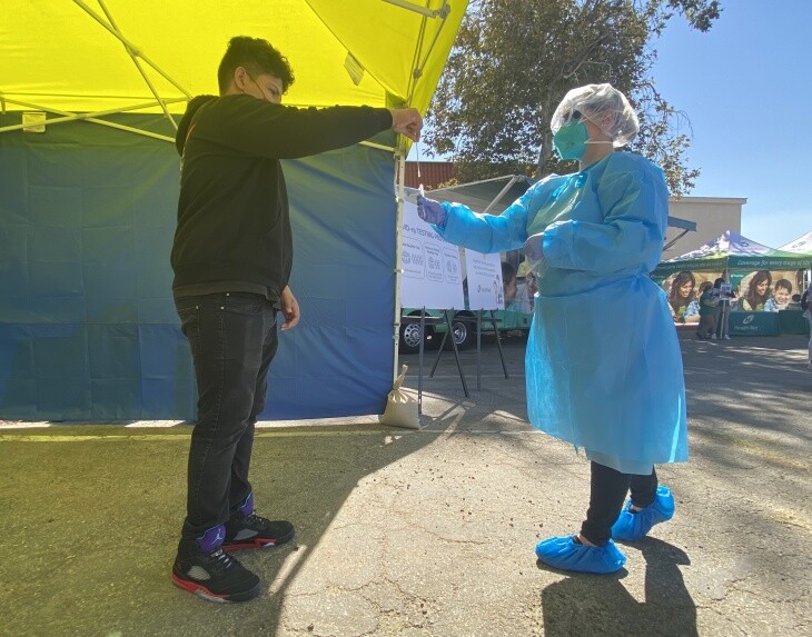 An L.A. Unified School District student drops a nasal swab from a COVID-19 test into a tube during a demonstration at San Fernando Middle School on Oct. 16, 2020.