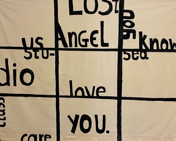 Angel and love and you are written with acrylic paint on a bedsheet